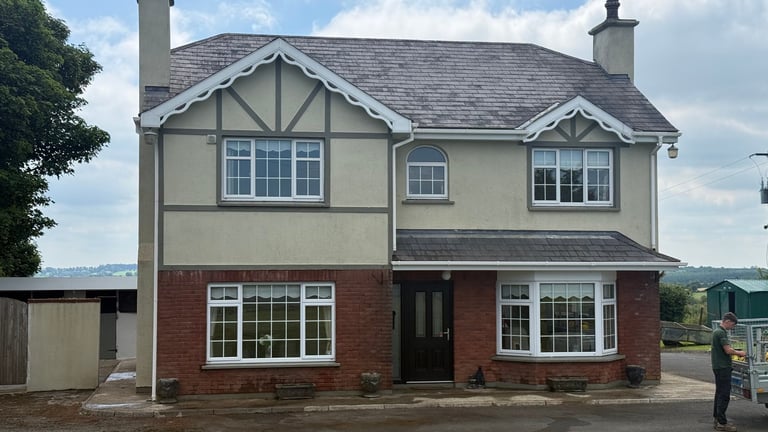 Two-story suburban house with red brick lower level, cream upper level with timber detailing